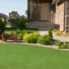 Emerald Green Turf 76 roll with vibrant synthetic grass and black woven backing, used for landscaping and sports applications in Texas.