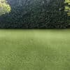 Emerald Green Turf 76 roll with vibrant synthetic grass and black woven backing, used for landscaping and sports applications in Texas.