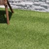 Emerald Green Turf 76 roll with vibrant synthetic grass and black woven backing, used for landscaping and sports applications in Texas.