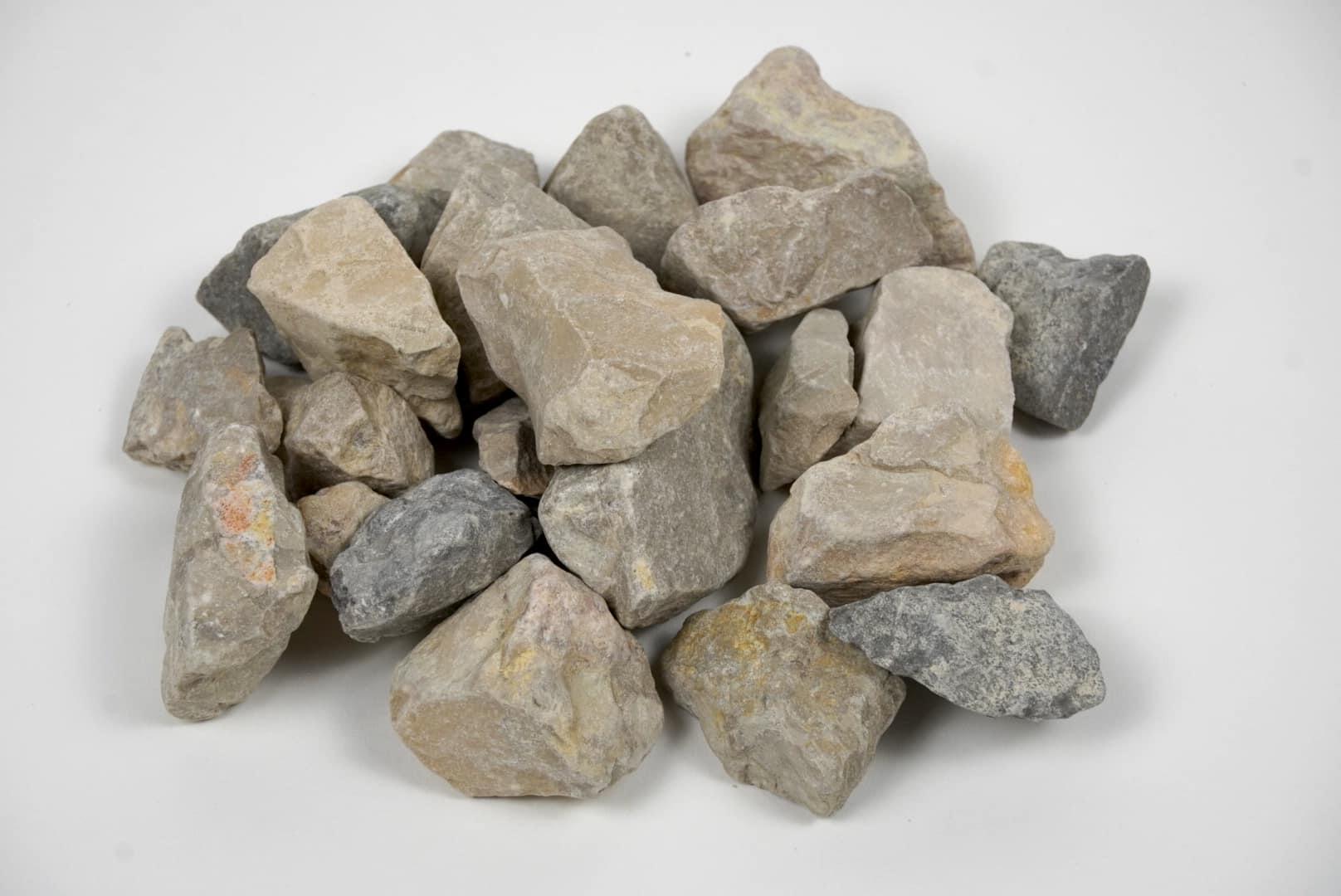 1-inch limestone rocks in varying shades of beige and gray, used for landscaping and construction in Texas.